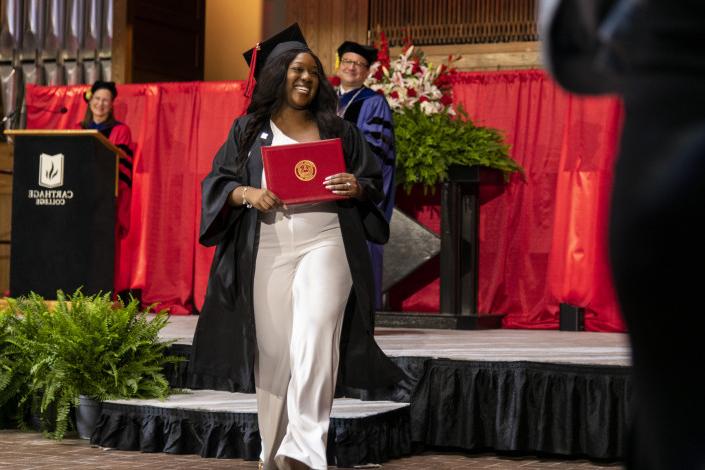 A 2023 全球十大赌钱排行app graduate beams as she leaves the Commencement stage after receiving her d...